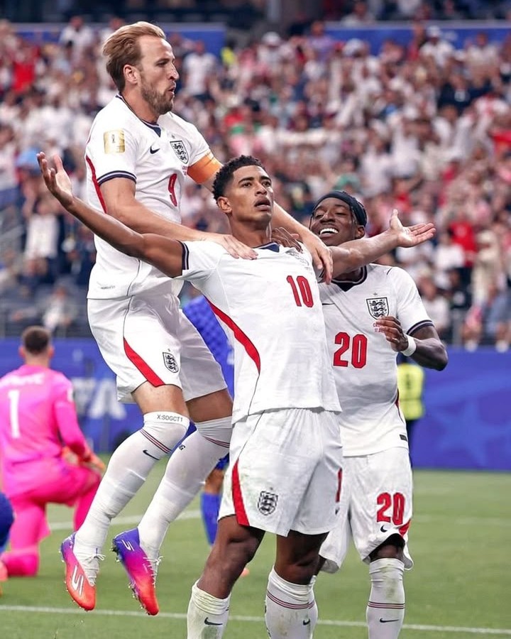 Football players celebrating a goal in a packed stadium